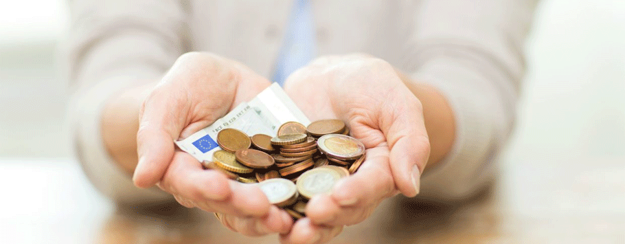 Opengevouwen handen met muntstukken