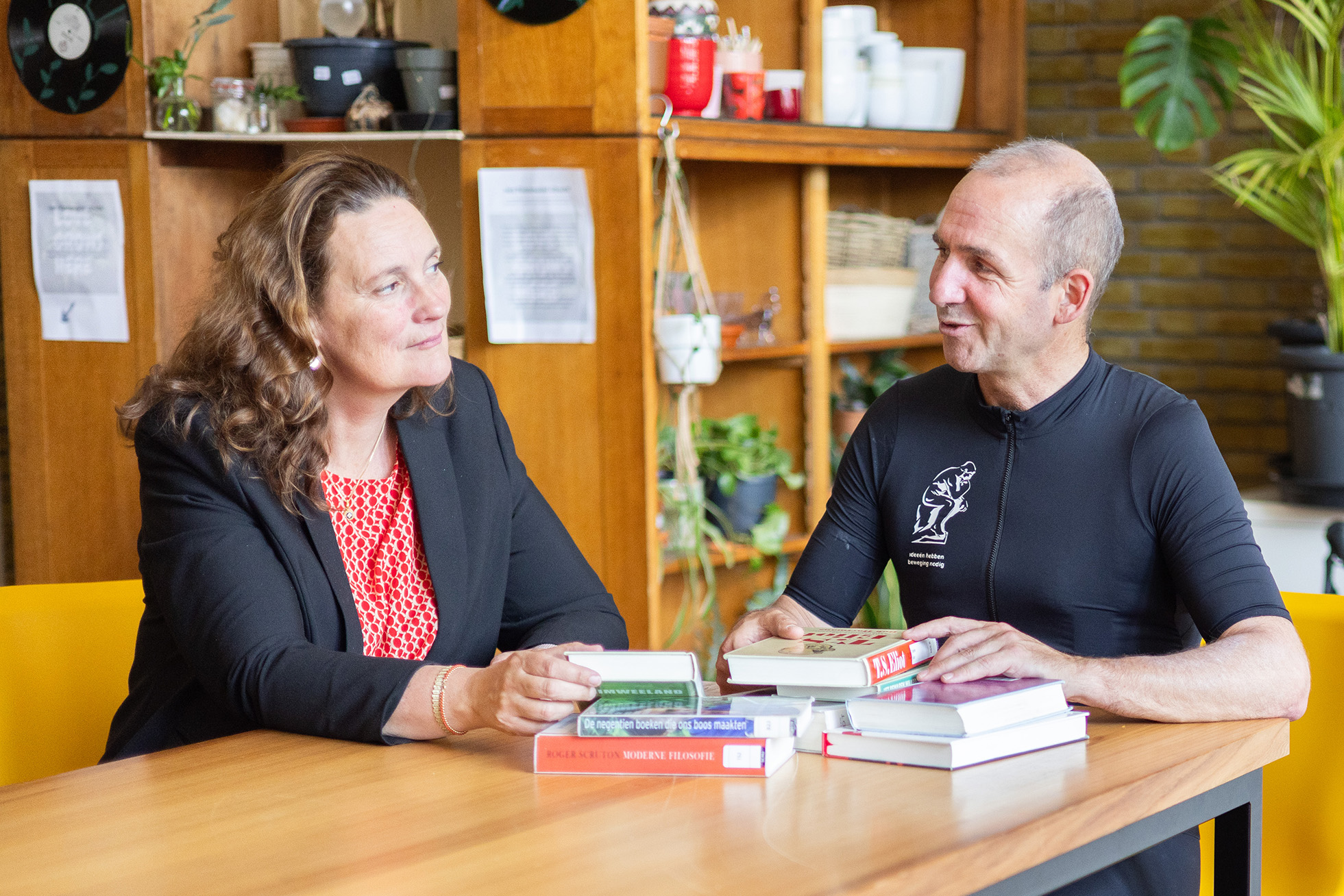 Deirdre Carasso en Menno Hurenkamp aan een tafel met boeken